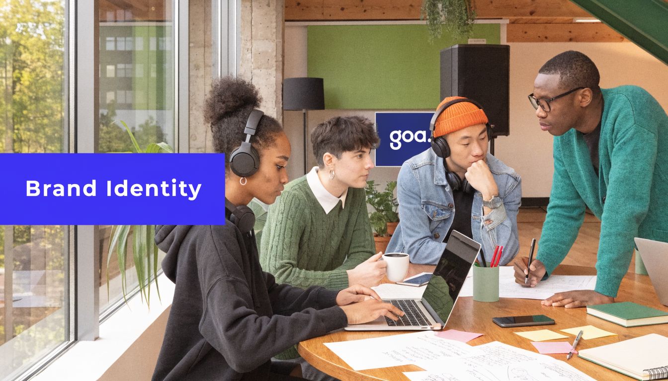 A diverse group of young creative professionals collaborating on a project around a wooden meeting table.