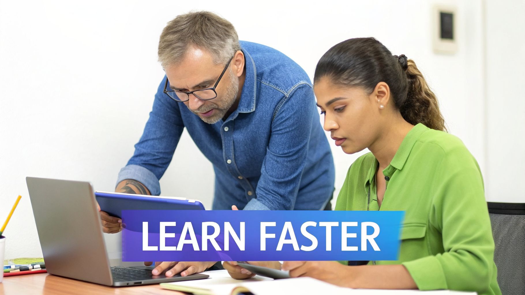 Two diverse professionals collaborate on a laptop and tablet, focused on a "Learn Faster" initiative.