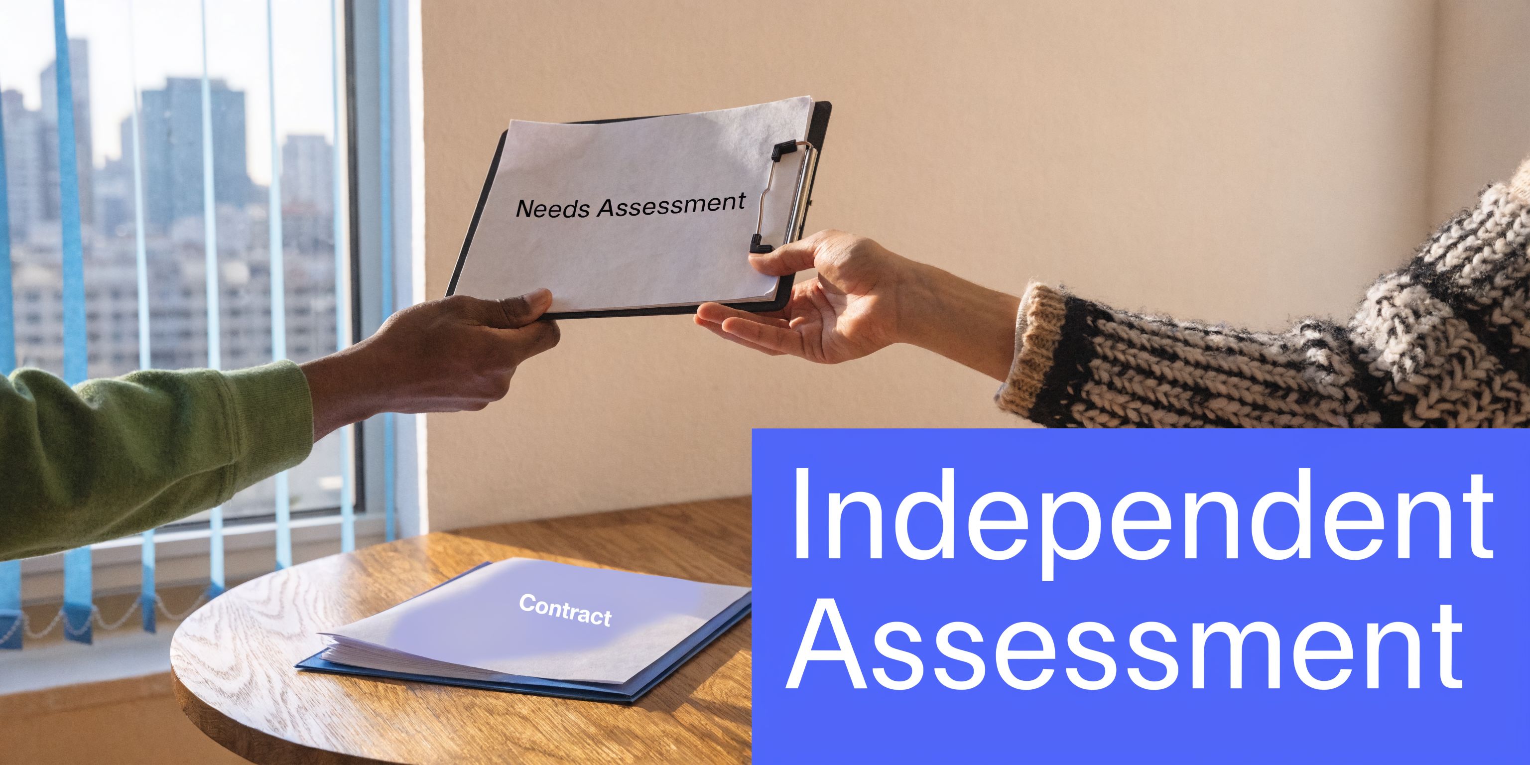 A person handing a clipboard labeled Needs Assessment to another person with a contract resting on a desk.