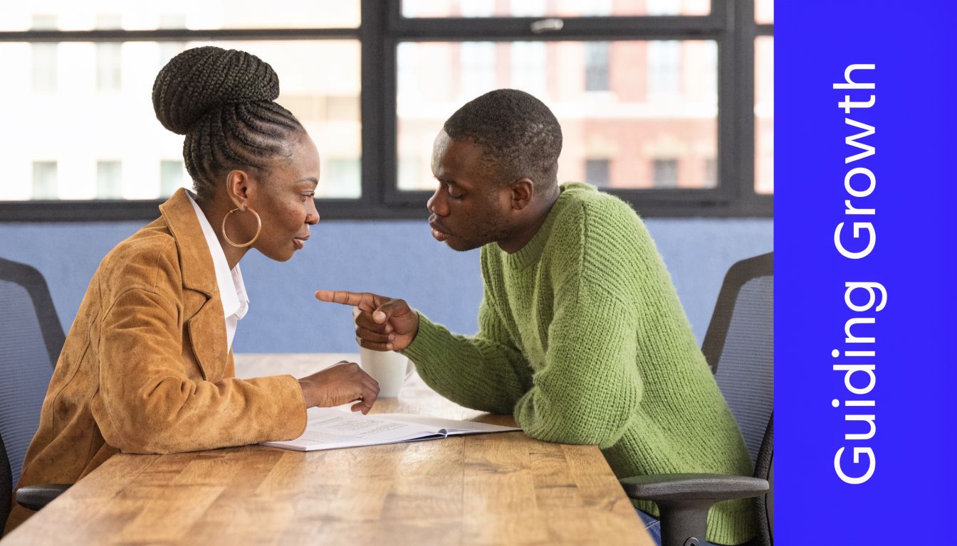 A professional manager and an employee reviewing documents together during a performance improvement plan discussion.