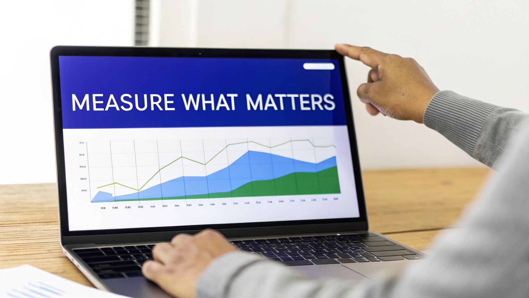 Person pointing at a laptop screen showing 'Measure What Matters' title and a data graph.