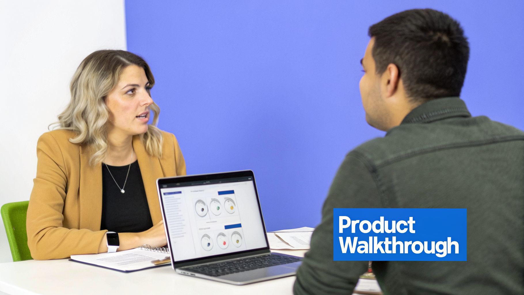 A woman demonstrates a product on a laptop to a man during a product walkthrough session.